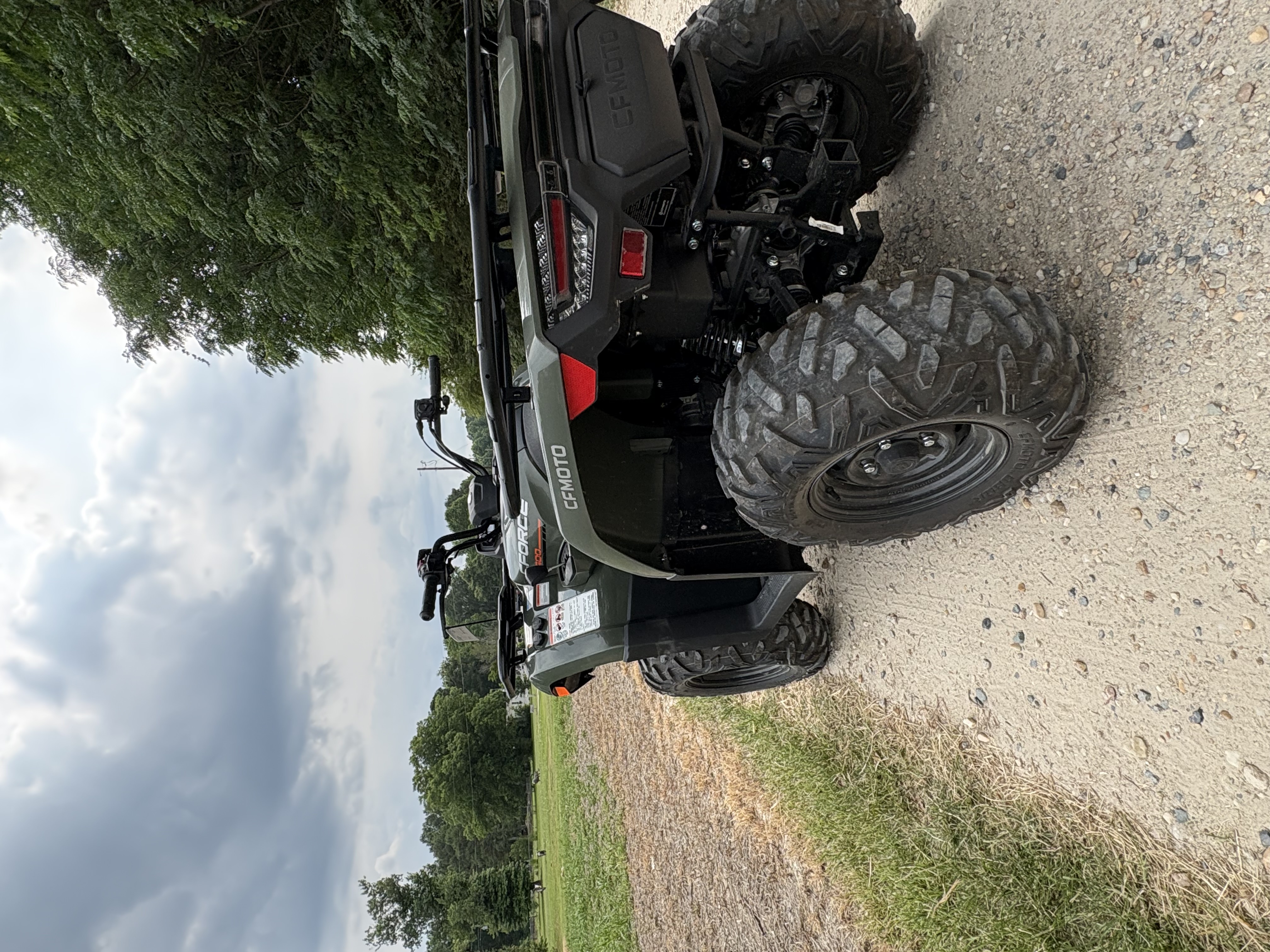 Green ATV parked on a gravel trail
